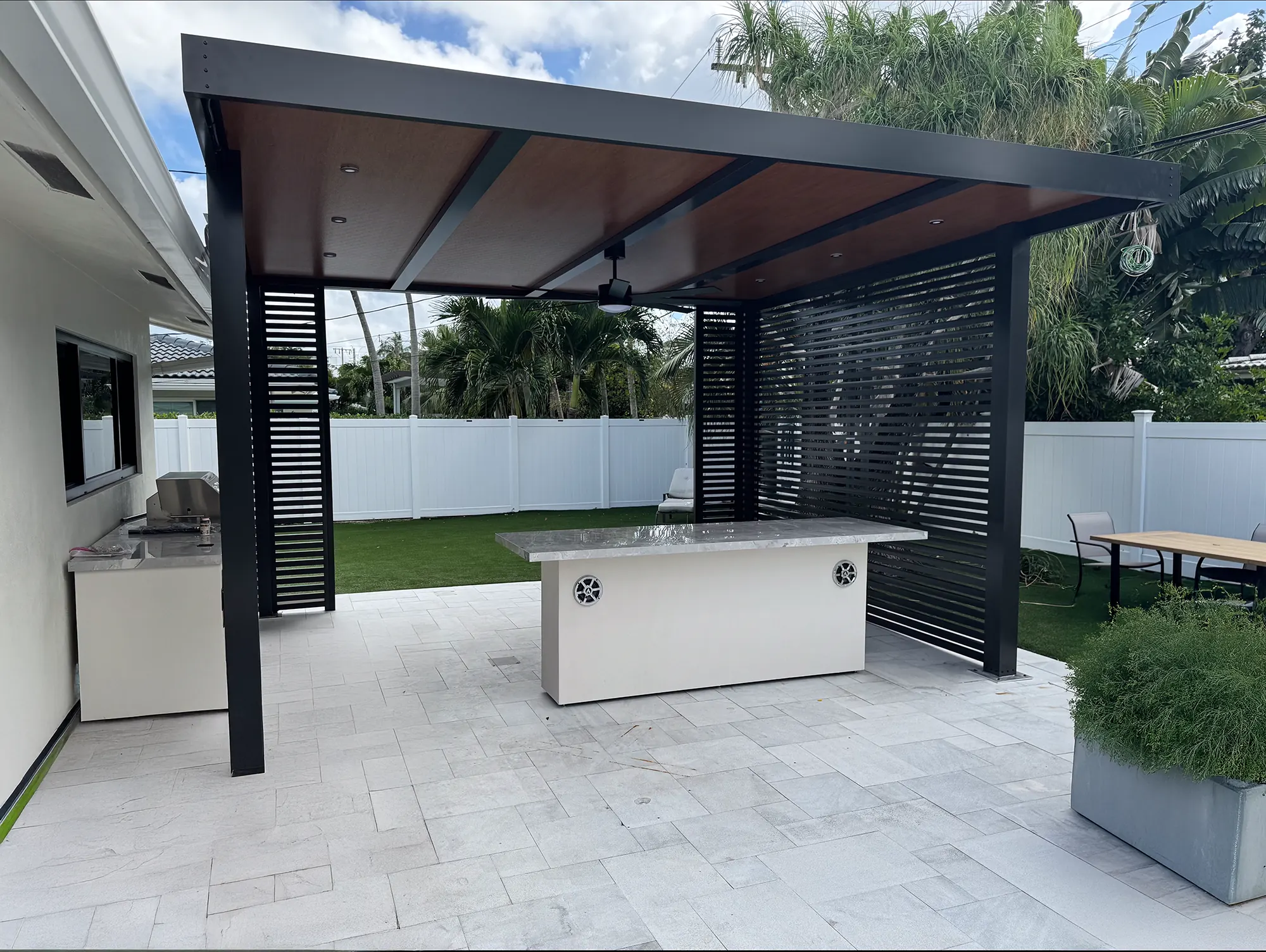 Elite aluminum outdoor kitchen with a covered gathering space and privacy screens