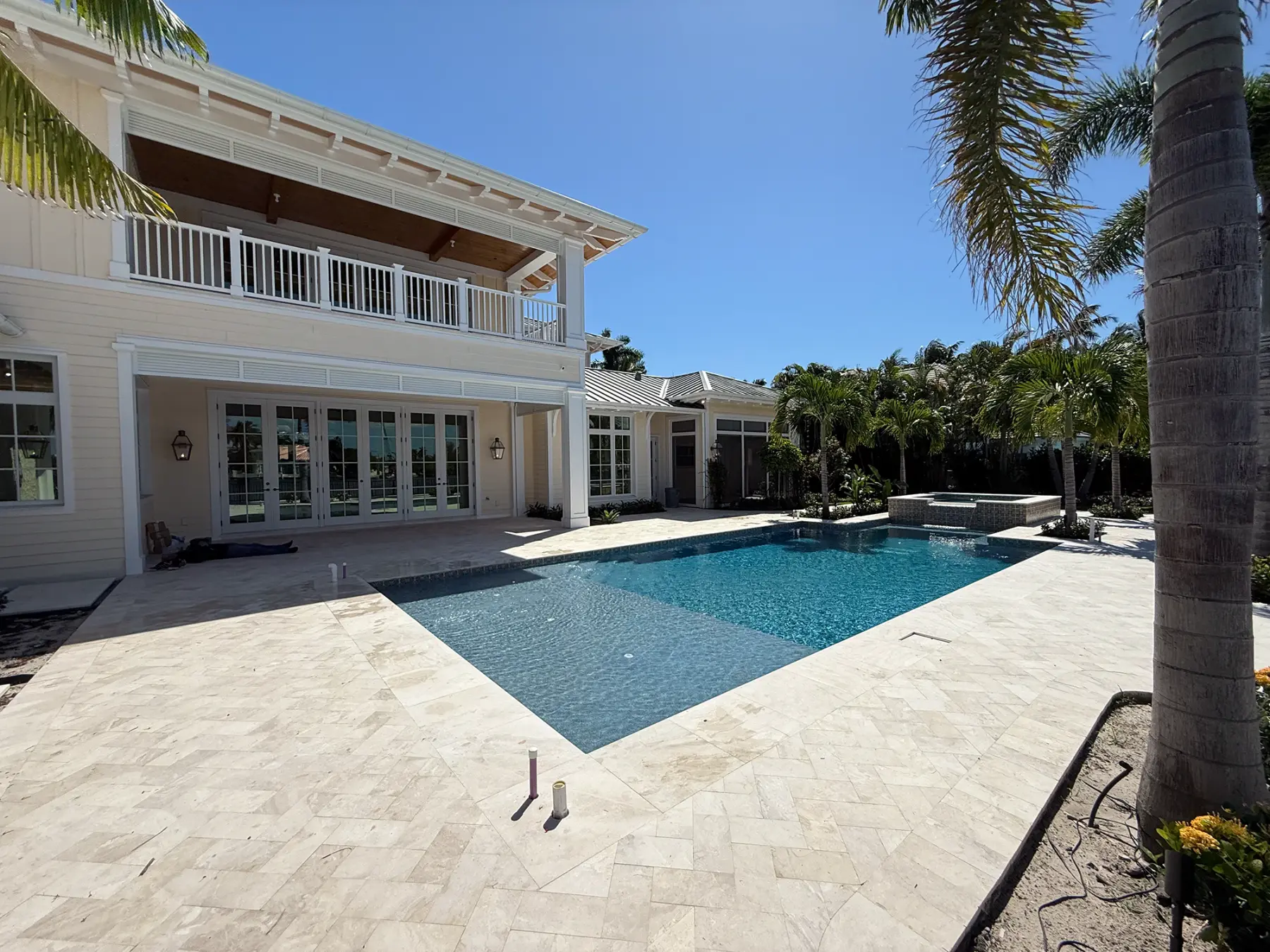 White Elite aluminum railing framing the upper terrace of a poolside residence